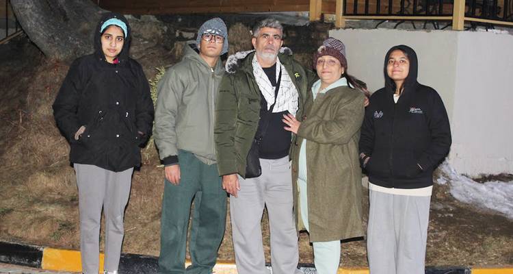 Cinq voyageurs en vêtements chauds se tiennent ensemble dans un cadre extérieur froid.