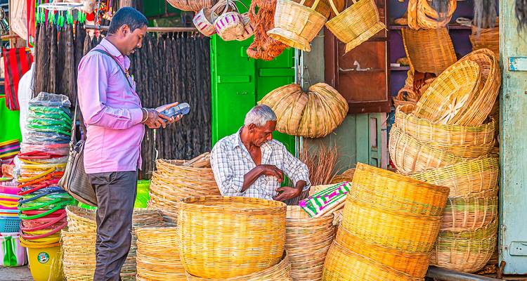 Vibrante escena callejera de vendedores de cestas entre pilas de productos tejidos en un mercado colorido.