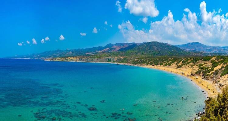 Long stretch of undeveloped golden sand beach meeting brilliant turquoise Mediterranean waters