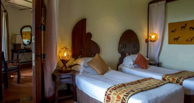Gemütliches Safari-Lodge-Zimmer mit zwei Einzelbetten, Holzdekoration und warmer Ambientebeleuchtung