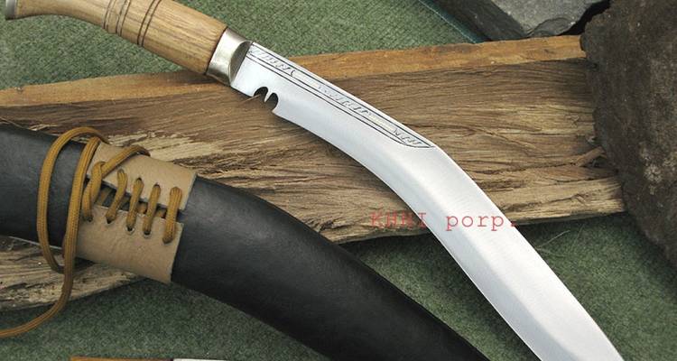 Detail of a finished kukri knife and sheath displayed on rustic wood