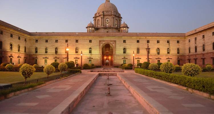 Le majestueux bâtiment du Secrétariat avec son dôme imposant à New Delhi est doucement illuminé en début de soirée.