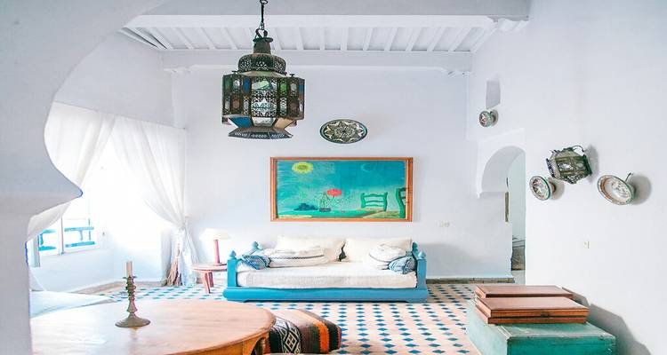 Bright, airy riad interior with traditional Moroccan lantern, patterned tiles and white walls.