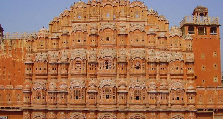 De sierlijke rood-zandstenen gevel van Jaipur's Hawa Mahal vullt het beeld.