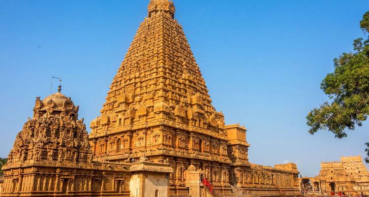 Massieve, ingewikkeld gebeeldhouwde zandstenen tempeltoren rijst op tegen een heldere blauwe hemel.