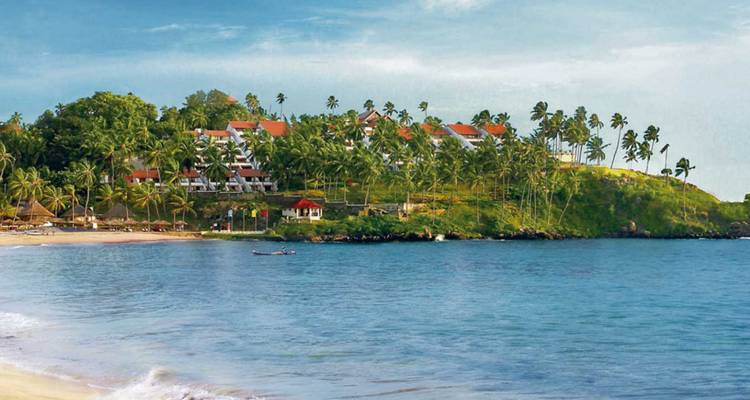 Resortcomplex gelegen op een weelderig groen schiereiland boven een rustige blauwe baai.