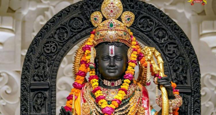 Ornately decorated Hindu deity statue draped in vibrant garlands inside a richly carved shrine.