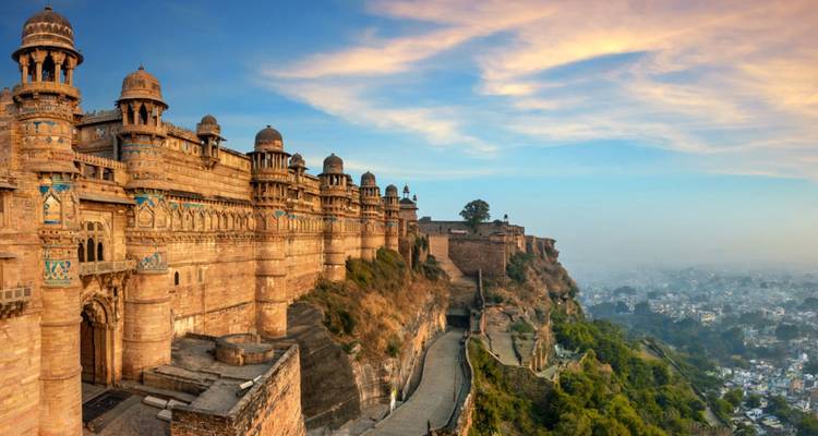 Panoramablick auf den Sonnenaufgang entlang der massiven befestigten Mauern der Gwalior-Festung mit Blick auf die Stadt und neblige Ebenen