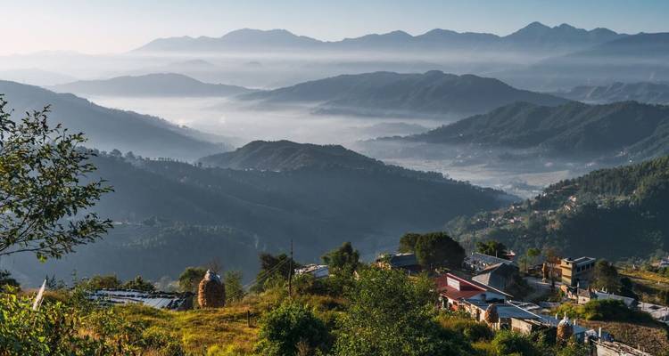 Panoramisch zonsopgangzicht van mistige bergkammen en dorpen in de valleien in de Himalaya