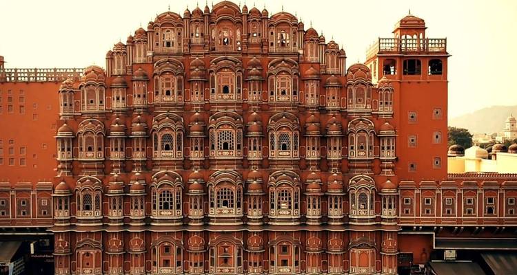 Façade chaleureusement éclairée du Hawa Mahal affichant ses fenêtres en nid d'abeille au coucher du soleil