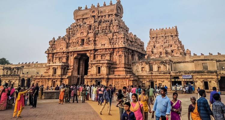 Des foules se rassemblent devant le temple orné en grès de Brihadeeswarar avec ses gopurams imposants et ses sculptures détaillées.