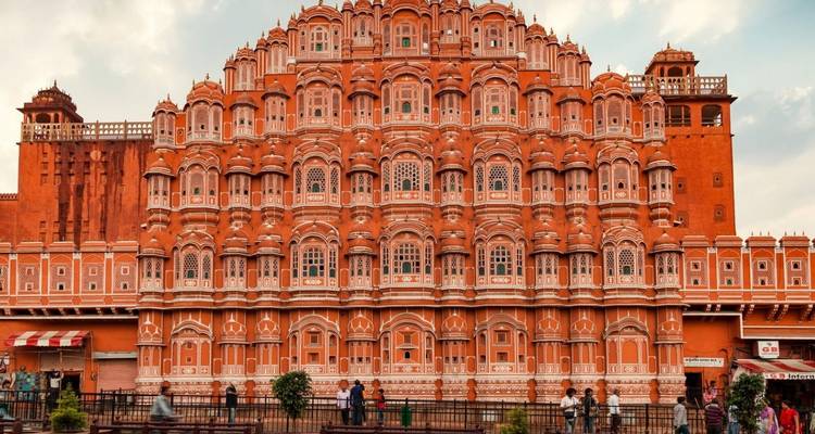 Breed zicht op Hawa Mahal's sierlijke terracotta gevel met het bruisende dagelijkse leven eronder