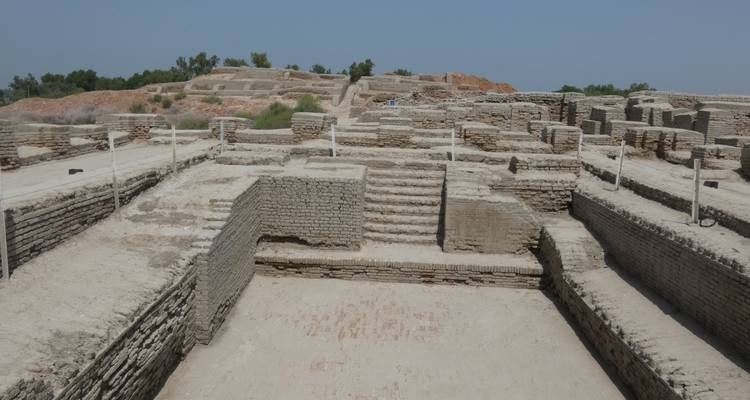Piscina rectangular hundida rodeada por antiguos muros escalonados de ladrillo dentro del sitio arqueológico.