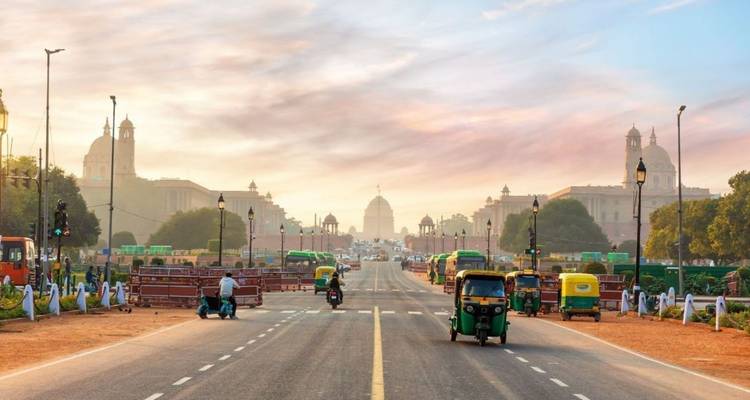 Weite Sicht entlang Delhis zeremonieller Rajpath in Richtung Rashtrapati Bhavan mit Auto-Rikschas auf der Straße im Morgengrauen.