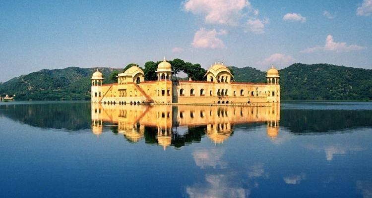 Der wasserumgebene Jal Mahal Palast spiegelte sich perfekt im ruhigen See wider, mit den Aravalli-Hügeln im Hintergrund.