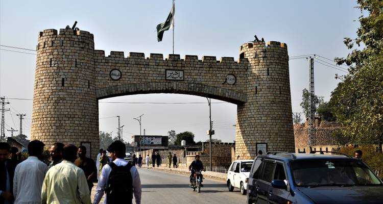 Portail en arc de pierre avec drapeau pakistanais et circulation, connu comme l'entrée du col historique de Khyber.