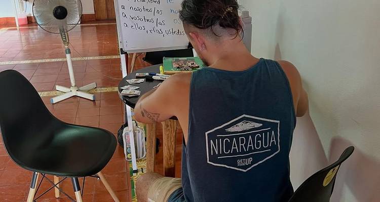 Binnenlandse Spaanse klaslokaal waar een student in een mouwloos Nicaragua shirt studeert aan een bureau