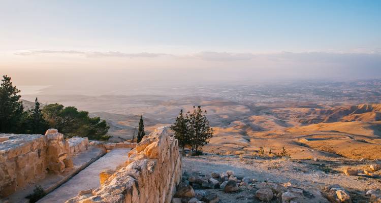 Weitläufiger Sonnenuntergangsblick vom Berg Nebo über karge Hügel zum Toten Meer.