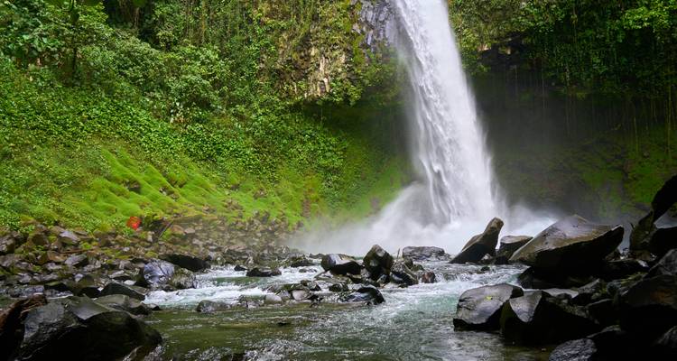 La puissante cascade de La Fortuna se jette dans un bassin brumeux entouré de falaises verdoyantes luxuriantes.