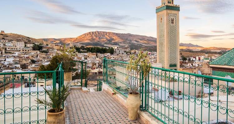 Vue sur la médina de Fès et le minaret depuis la terrasse sur le toit au coucher du soleil.