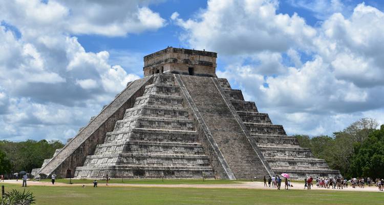 La pyramide d'El Castillo domine Chichén Itzá sur un fond de nuages brillants.