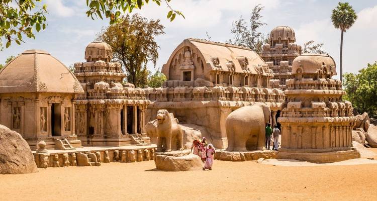 Die Pancha Rathas Felsentempel stehen auf sandigem Boden unter einem hellen Himmel in Mahabalipuram.