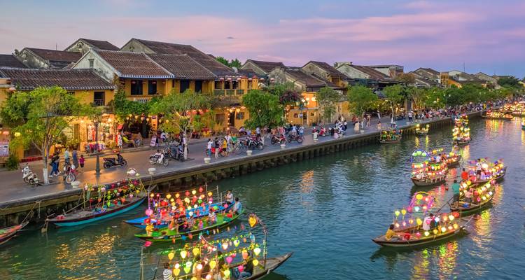 Hoi An’s lantern-lit river comes alive at dusk with boats covered in colorful floating lights.