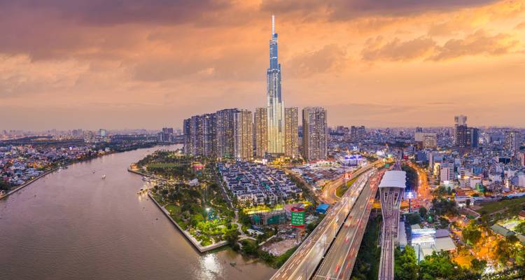 Ho Chi Minh City skyline with Landmark 81 tower silhouetted against a fiery sunset above the Saigon River.