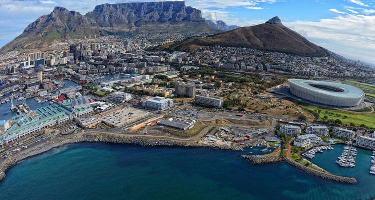 Impresionante vista aérea de Ciudad del Cabo con Table Mountain, el centro de la ciudad, el puerto y el estadio junto al mar turquesa.
