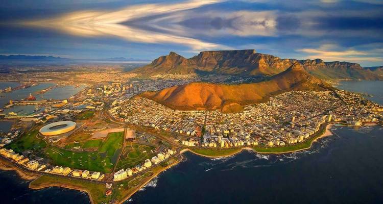 Repetir panorama aéreo del atardecer de Ciudad del Cabo y Table Mountain con patrones de cielo vívidos.