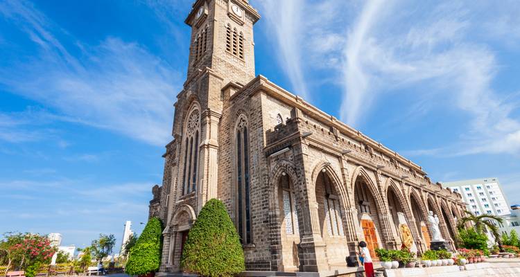 Cathédrale en pierre du Christ-Roi dominant Nha Trang sous un ciel bleu.