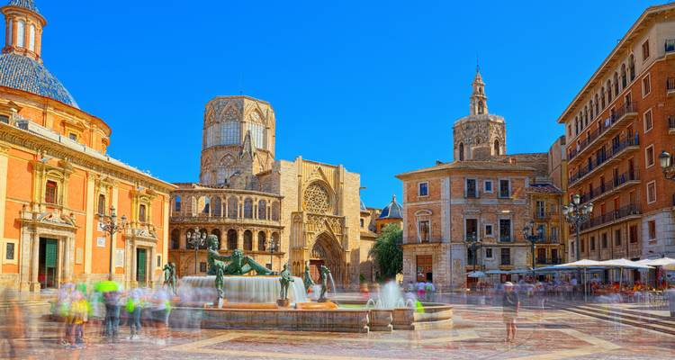Colourful Plaza de la Virgen with Valencia Cathedral and blurred crowds captured in long exposure.