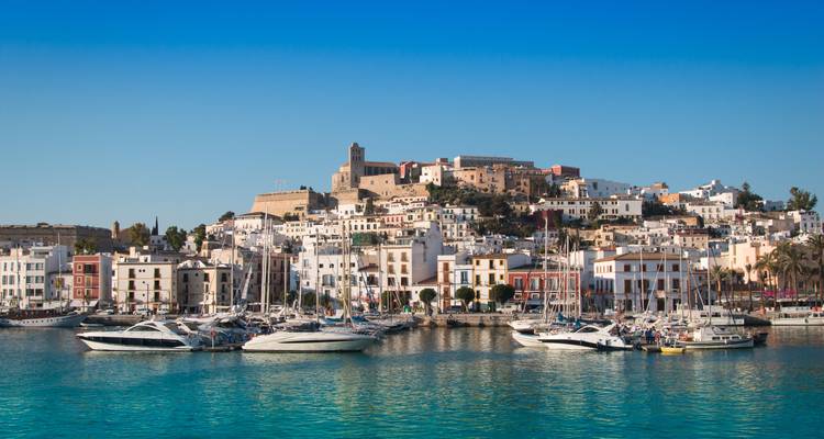 Ibiza-Stadts weiß getünchte Gebäude und Marina voller Yachten unter einem klaren blauen Himmel.