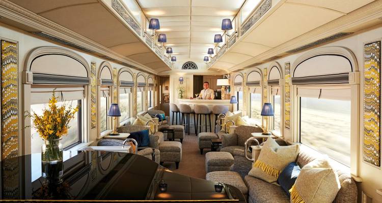 Elegant lounge car of a luxury train with plush seating, bar, and grand piano.