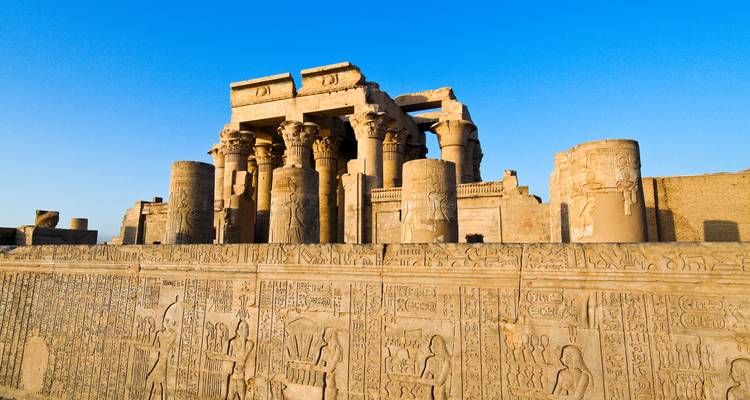 Columnas de arenisca bien conservadas y muros cubiertos de jeroglíficos del Templo de Kom Ombo bajo el cielo azul