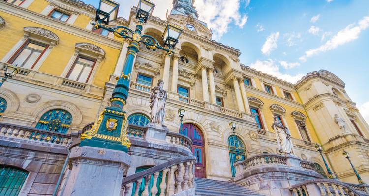 Escalier orné menant à la façade grandiose de l'Hôtel de Ville de Bilbao sous un ciel bleu