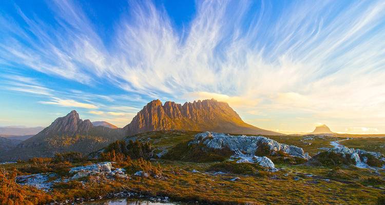 Dramatic mountain ridges bathed in golden evening light in Tasmania’s Cradle Mountain-Lake St Clair National Park.
