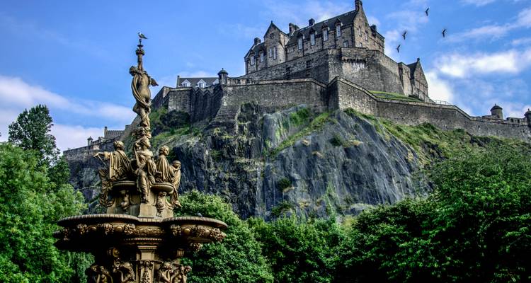 Vista de la Fuente de Ross con el Castillo de Edimburgo alzándose dramáticamente sobre el risco de basalto detrás.