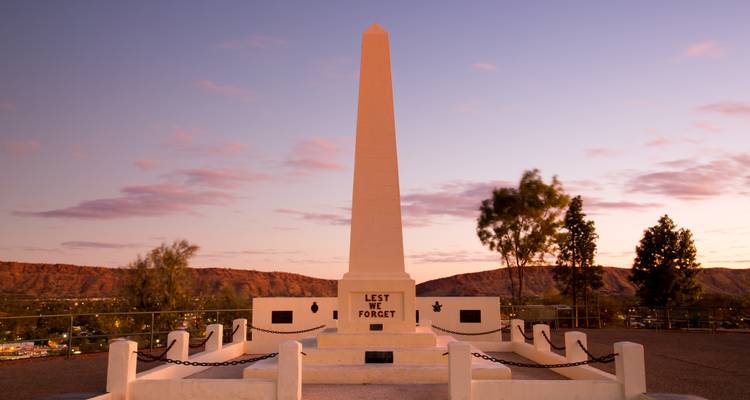 Anzac Hill war memorial obelisk overlooking Alice Springs at twilight.