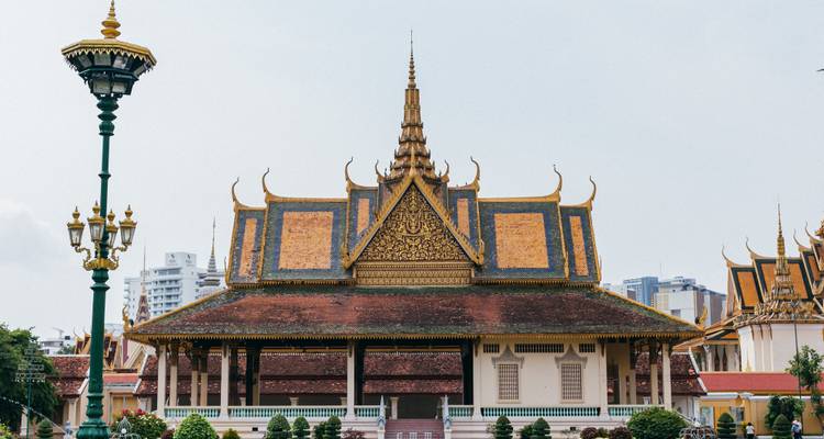 Symmetrical frontal view of an ornate Khmer palace hall with golden-tiled roof and decorative spire.