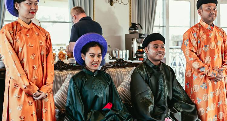 Des artistes en traditionnel ao dai vietnamien accueillant les passagers à bord d'une croisière.