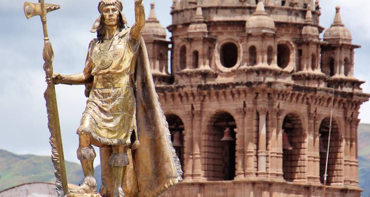 Statue dorée d'un chef inca avec une église historique de Cusco en arrière-plan.
