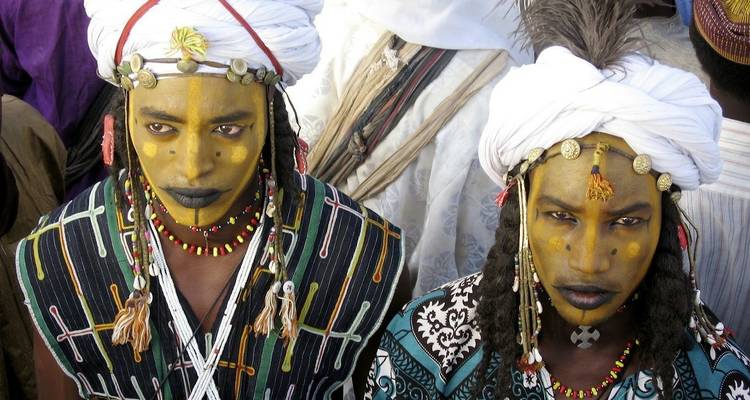 Wodaabe-Männer mit aufwendiger Gesichtsbemalung und traditioneller Kleidung während eines Kulturfestivals.