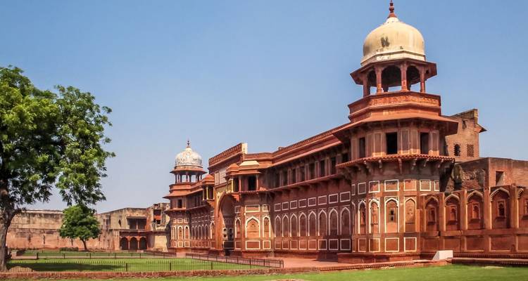 Long facade of a historic Mughal palace complex featuring arcaded verandas and domed pavilions.