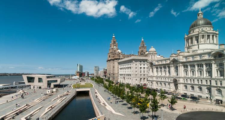 Sonniger Tag an Liverpools historischer Uferpromenade mit den Three Graces und dem modernen Museum.