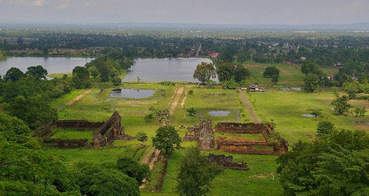Luftaufnahme der antiken Khmer-Ruinen und Teiche von Wat Phou inmitten üppiger Landschaft.