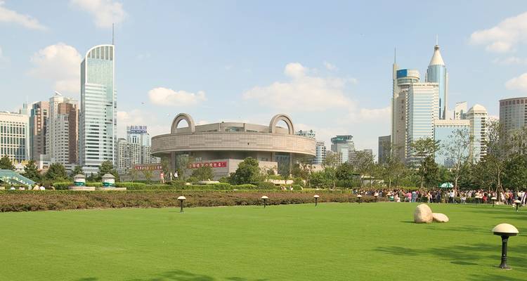 Horizonte moderno de Shanghái con parque urbano y amplio césped verde en primer plano.
