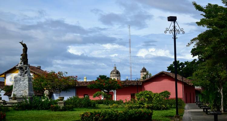 Colonial-style red and yellow buildings and a small park set against a dramatic cloudy sky.