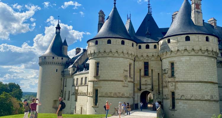 Visitors explore Château de Chaumont-sur-Loire’s robust towers and stone walls beneath a bright sky.