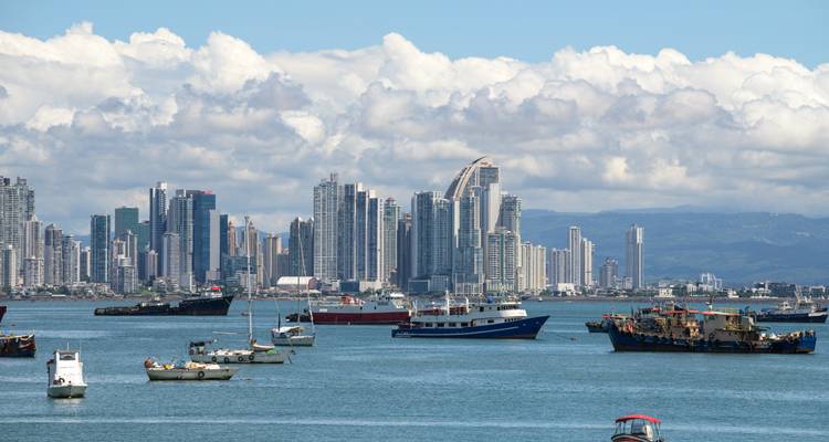 Panama City modern skyline rising behind a harbor filled with fishing and tour boats on a sunny day